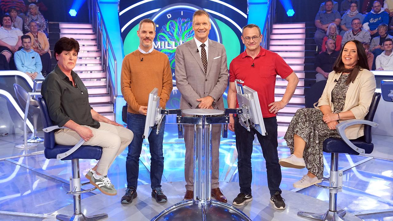 Sonja Fischer, Pierre Douay, Armin Assinger, Gerhard Brunner und Marion Dygryn stehen gemeinsam um den "Millionenshow"-Pult im TV-Studio mit Publikum im Hintergrund.
