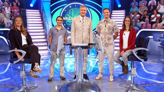 © ORF/Stefan Gregorowius Nadine Köpf, Markus Fleischmann, Armin Assinger, Peter Seidler und Laura Seebacher stehen gemeinsam um den "Millionenshow"-Pult im TV-Studio mit Publikum im Hintergrund.