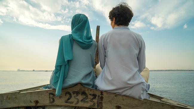 © ORF/Rosa Lyon Ansicht von hinten von Rosa Lyon im Gespräch mit Muqaddas Tahir, die im Bug eines kleinen Holzbootes sitzen und über ruhiges Wasser in den wolkigen Himmel blicken.