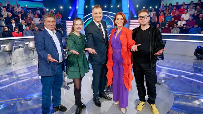 Hans Bürger, Anna Strigl, Armin Assinger, Maya Hakvoort und Max Stiegl stehen im Millionenshow-Studio vor dem Logo der Show und präsentieren sich dem Publikum.