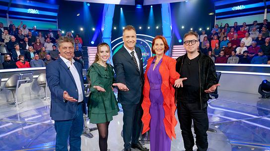 Hans Bürger, Anna Strigl, Armin Assinger, Maya Hakvoort und Max Stiegl stehen im Millionenshow-Studio vor dem Logo der Show und präsentieren sich dem Publikum.