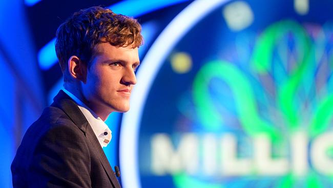 © ORF/Stefan Gregorowius Johannes Aigner ist im Profil vor dem farbig leuchtenden Studiodesign im "Promi-Sportler-Millionenshow"-Studio zu sehen.