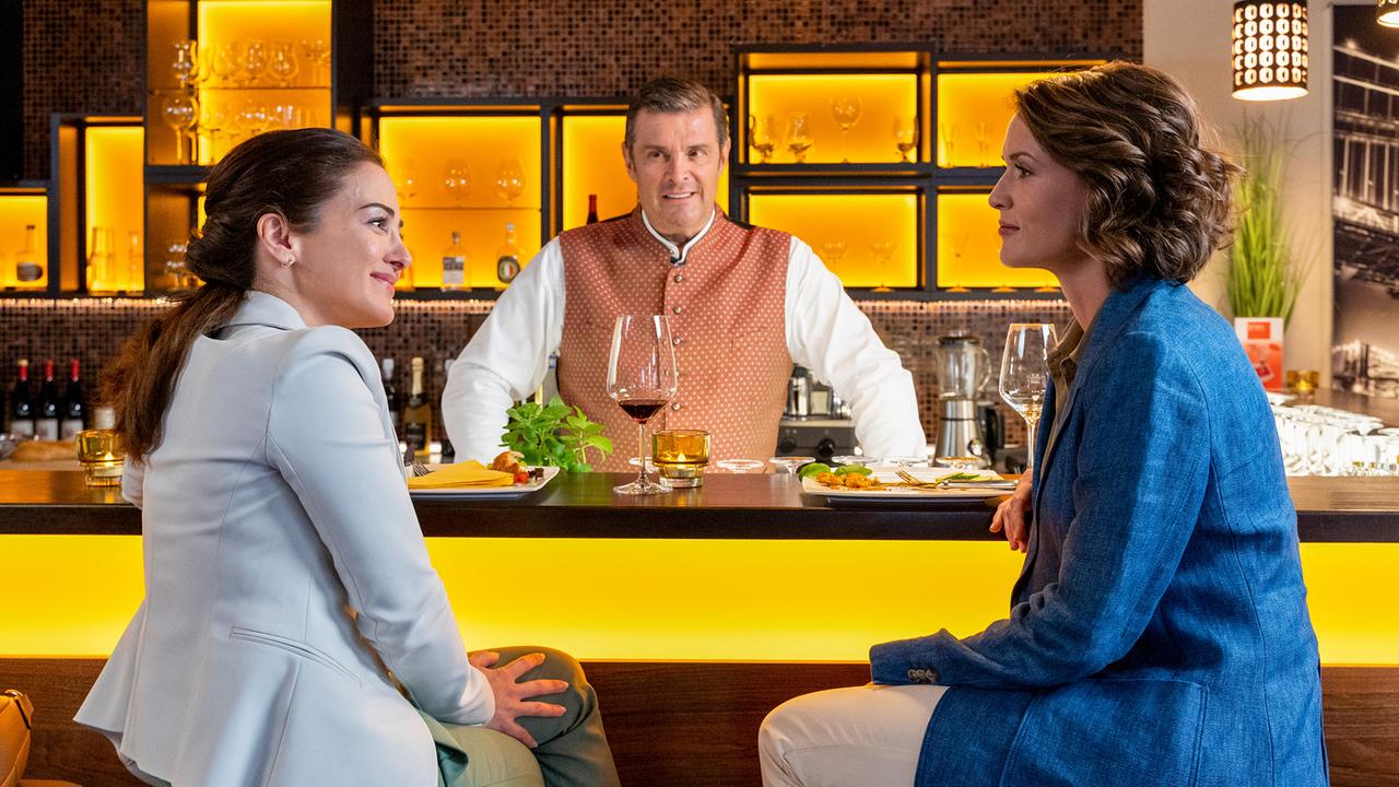 Im "Times Square" unterhält sich Jo mit Kommissarin Andresen und Rechtsmedizinerin Atay über den Verein "Bierfreunde Oberbayern".