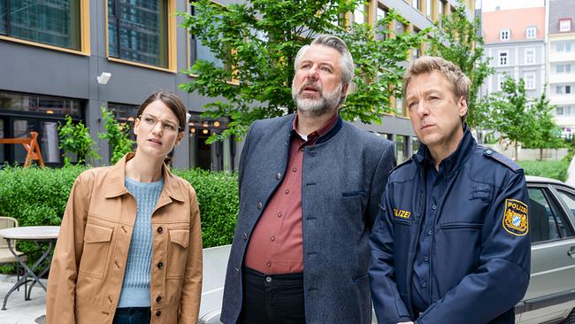 © ORF/ZDF/Linda Gschwentner Kommissarin Beck, Kommissar Stadler und Polizeihauptmeister Mohr stehen nebeneinander in einer Fußgängerzone mit Bäumen und blicken skeptisch in dieselbe Richtung