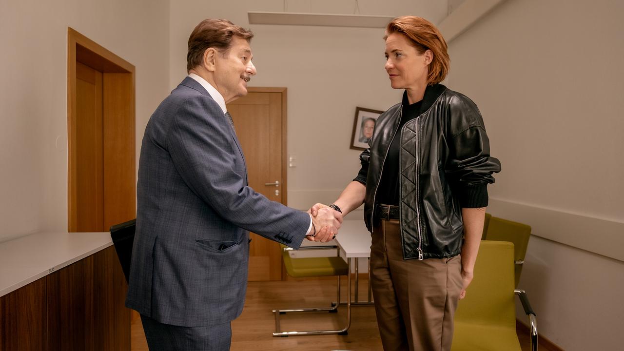 Alfons Seywald gibt Lu Frey die Hand in einem Büro.