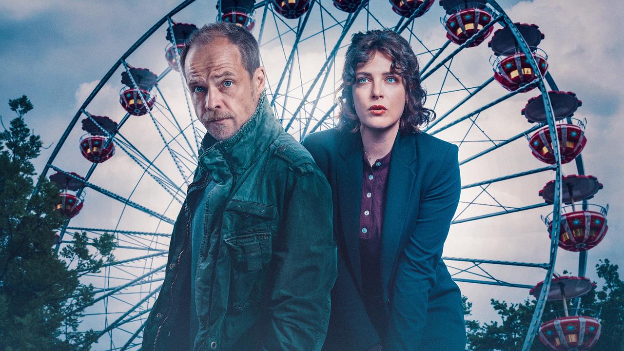 © ORF/Graf Film/Manuel Riesterer Micha Oberländer und Mara Eisler stehen vor einem großen Riesenrad bei Abenddämmerung.