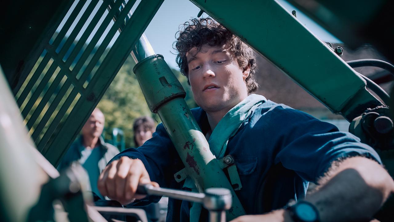 © ORF/Graf Film/Lukas Gnaiger Dominik Wimmer arbeitet mit Werkzeug an einer großen Metallkonstruktion im Freien.