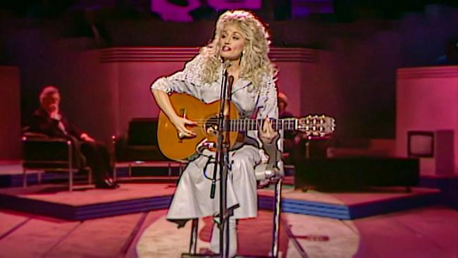 Dolly Parton mit Gitarre auf Bühne