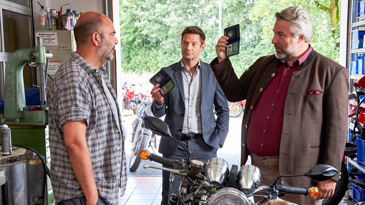 © Foto: ORF/ZDF/Bojan Ritan Im Bild: Die Kommissare Hansen (Igor Jeftic, M.) und Stadler (Dieter Fischer, r.) befragen den Besitzer einer Motorradwerkstatt, Bernhard „Bulli“ Kuhn (Hannes Ringlstetter, l.), denn das Mordopfer war sein Kunde.