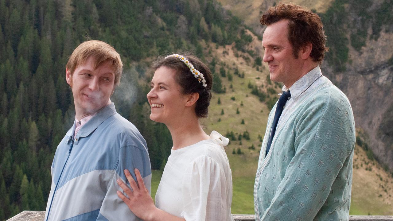 Braut Elfi im weißen Kleid, ihr Bruder Fritz  und Sepp im Anzug genießen die Aussicht mit Blick ins Bergtal, bevor sie in das Gemeindeamt gehen.
