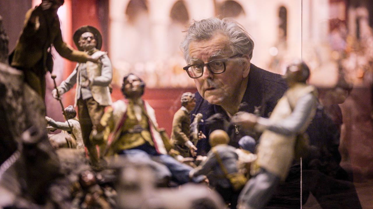 Johannes Silberschneider schaut sich in einer Auslage Grippenfiguren an.