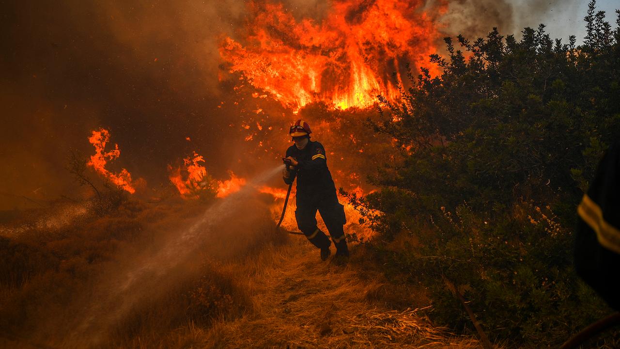 Ein Feuerwehrmann löscht am 16. August 2021 mit einem Wasserschlauch einen Brand im Dorf Markati bei Athen.