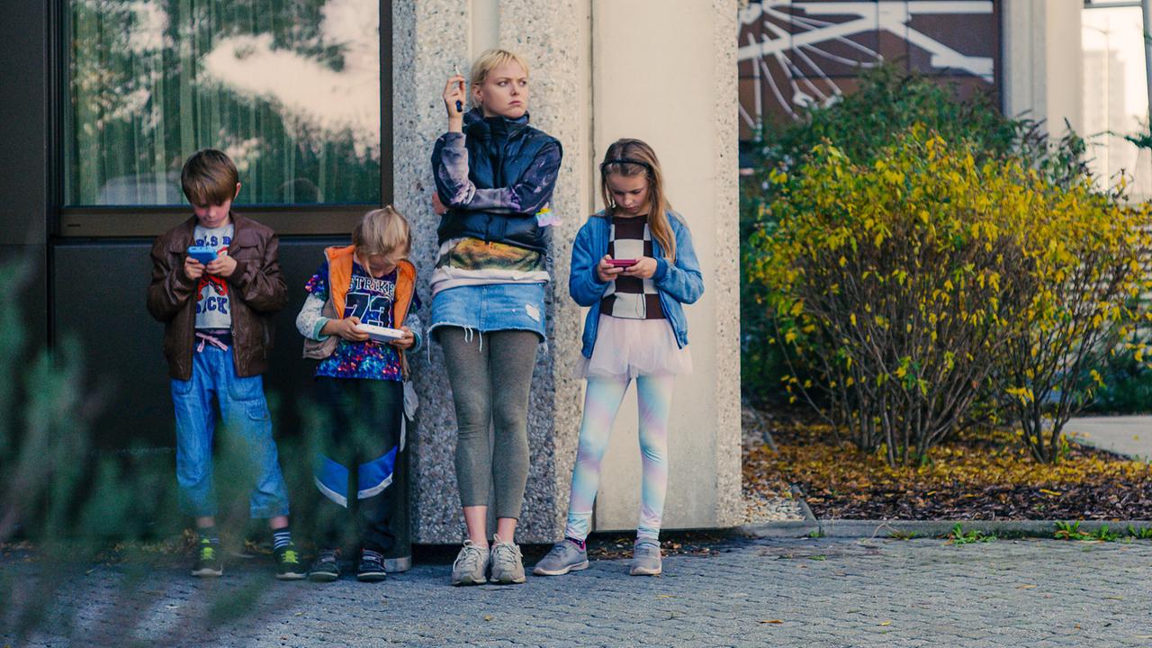 © ORF/Film AG Gitte steht rauchend mit den Kindern Leon, Niko und Gina vor einem Gebäude an der Mauer lehnend im Freien.