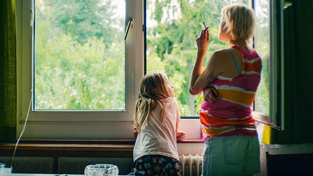 © ORF/Film AG Gina steht mit der rauchenden Gitte am geöffneten Fenster und schaut nach draußen.