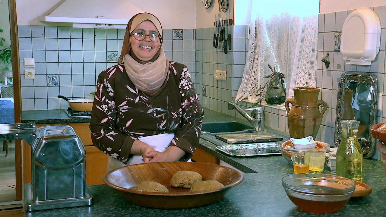 Eine Marokkanerin in ihrer Küche, lachend.