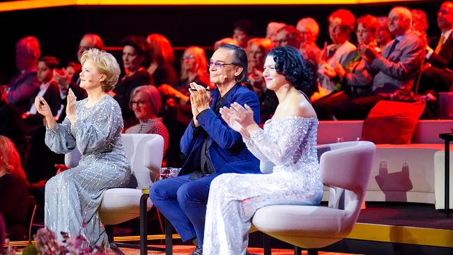In einem festlich beleuchteten Studio sitzen Ildikó Raimondi, Christian Kolonovits und Khatia Buniatishvili in eleganter Kleidung auf auf gepolsterten Sesseln und applaudieren, während im Hintergrund ein Publikum zu sehen ist.