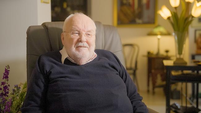 Felix Dvorak sitzt in einem ledernen Bürosessel in einem Wohnraum
