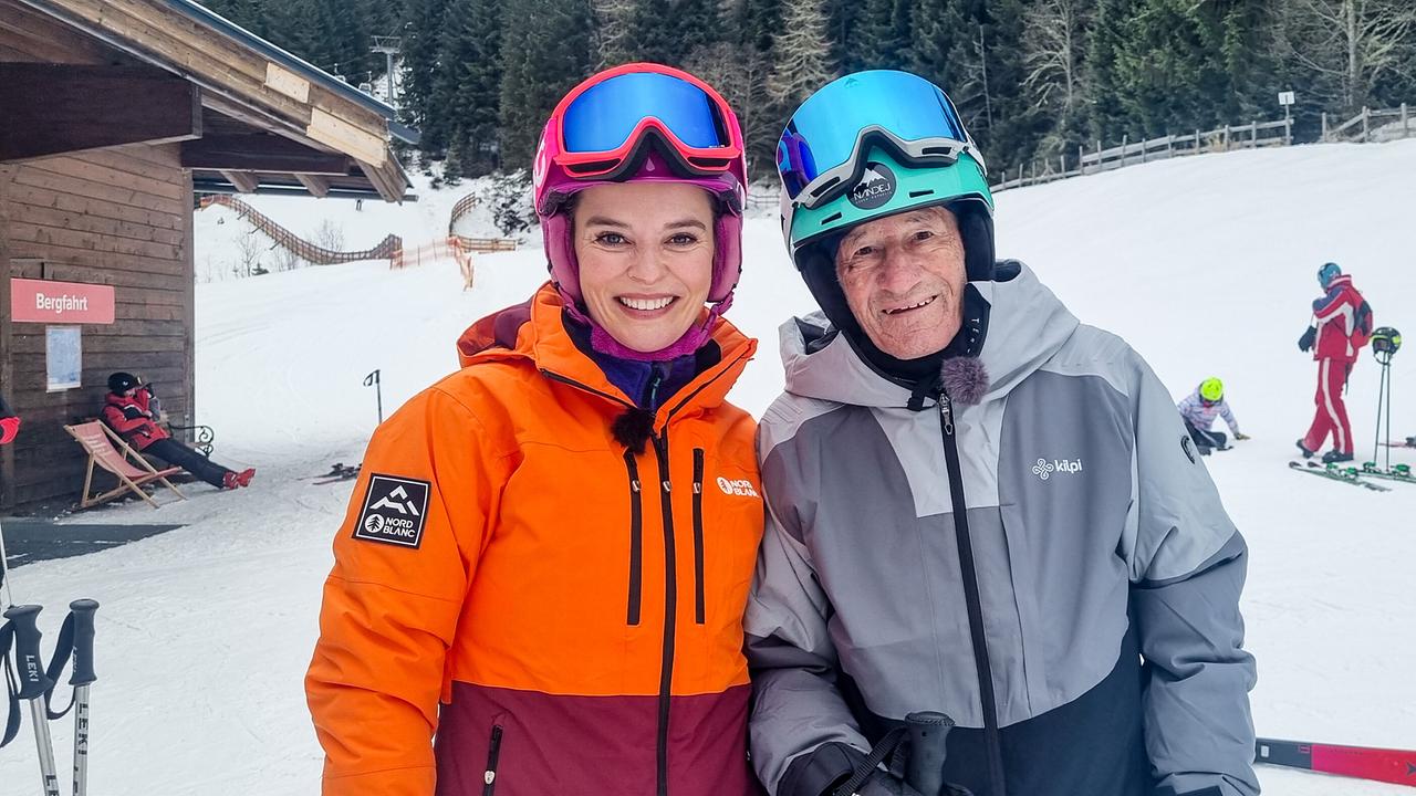 © ORF/Kiwi TV Christine Reiler und Gottfried Bistumer, beide in Skibekleidung, posieren vor einer Skipiste.