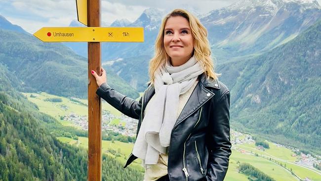 Dr. Christine Reiler im Tiroler Ötztal an einem Wegweiser mit dem Schriftzuz "Umhausen", oberhalb jenes Ortes, der weltweit eine der höchsten Radonkonzentrationen in der Luft aufweist.