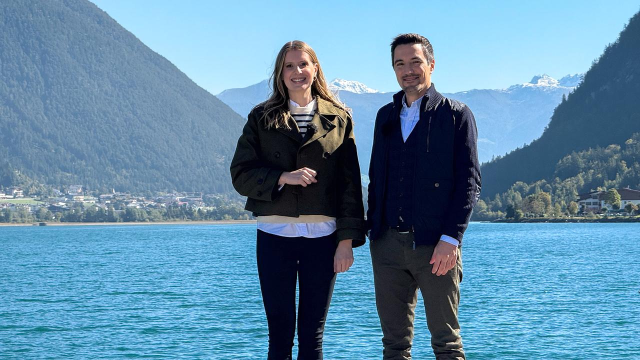 Die Moderatoren Raphaela Pint und Marius Holzer stehen vor einem See.