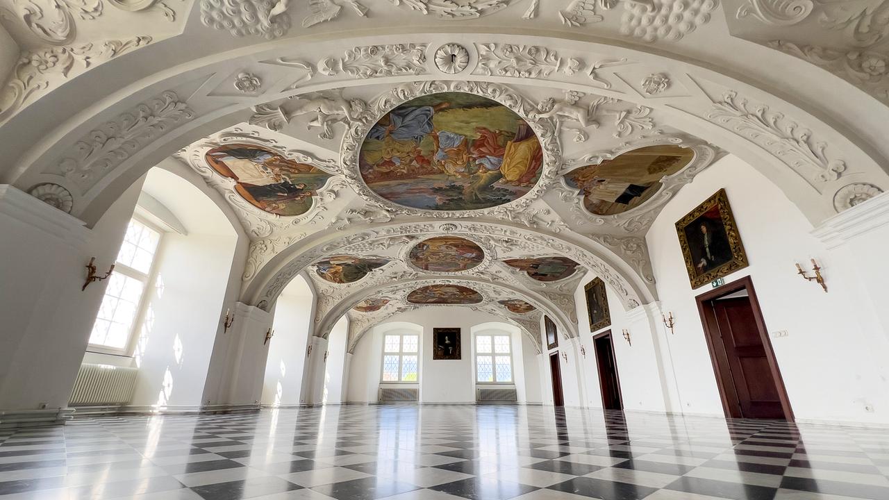 © ORF/Interspot/Philip Pürcher, Carlo Hofmann Ein prächtiger, heller Saal im Schloss Stainz mit barocken Deckenfresken und schwarz-weißem Fliesenboden