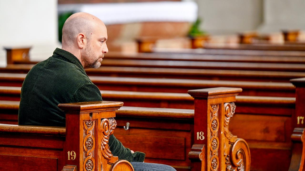 Hans Reiser sitzt allein nachdenklich in einer Kirchenbank.