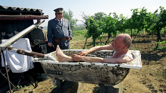 © ORF/Teamfilm/Wolfgang Fuhrmann Der uniformierte Gendarm Simon Polt steht vor einem Mann, der in einer alten Badewanne mitten in einem Weinberg liegt.