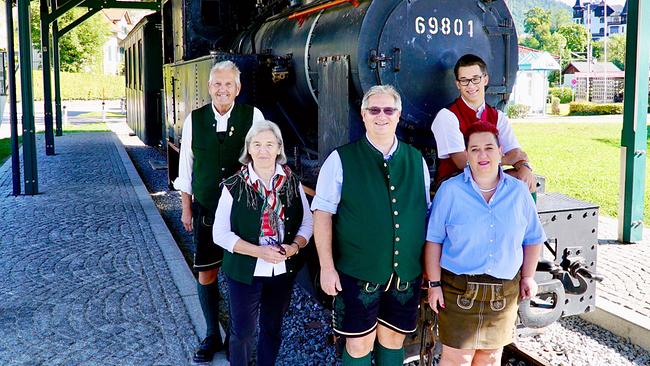 3 Generationen der Eisenbahnerfamilie Deopito: 1.Generation: Alfred und Anna Deopito (links), 2. Generation: Ludwig und Daniela Deopito (mitte) mit Sohn Dominik Deopito (rechts hinten) in der 3. Generation stehen vor der historischen Dampflok 69801 an einem überdachten Bahnsteig.