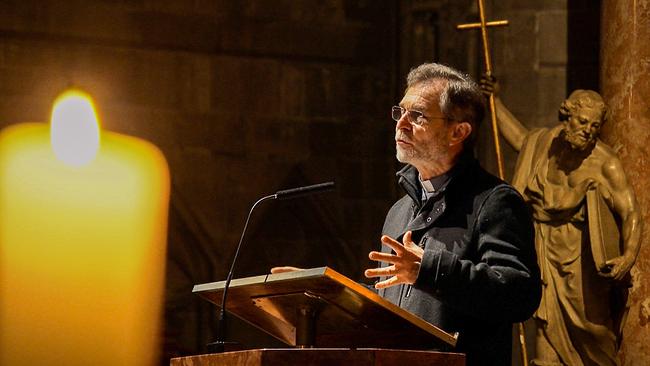 © ORF/Robert Neumüller Der designierte Wiener Erzbischof Josef Grünwidl spricht am Lesepult einer dimmlicht erleuchteten Kirche, während eine große Kerze im Vordergrund warm aufleuchtet.