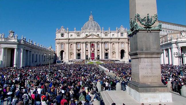 © ORF Eine große Menschenmenge versammelt sich auf dem Petersplatz vor dem Petersdom im Vatikan bei strahlendem Tageslicht.