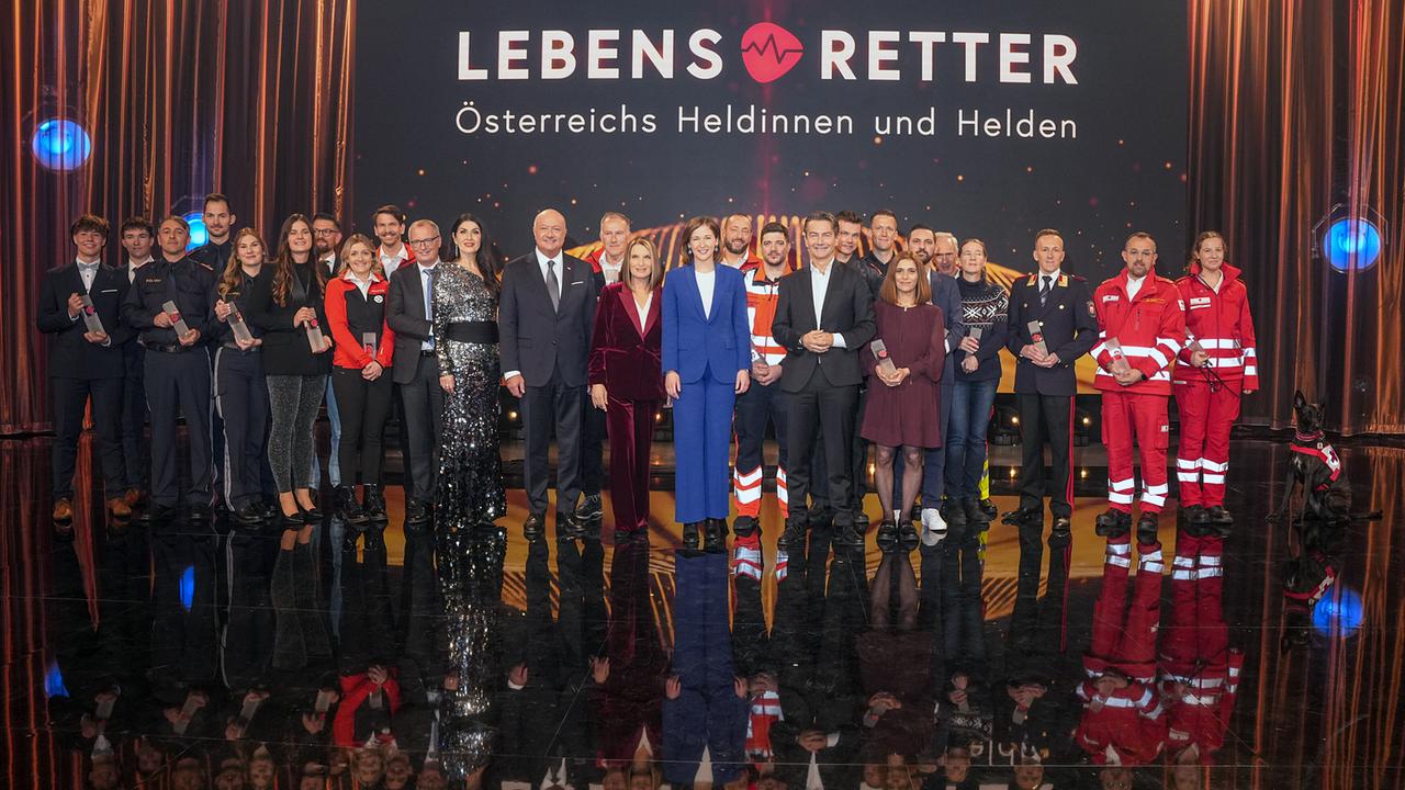 Gruppenfoto mit ORF-Generaldirektor Roland Weißmann, Bundeskanzler Christian Stocker, Bundesministerin Claudia Plakolm, Barbara Stöckl, Monika Ballwein und Klaus Herrmann mit Österreichs Heldinnen und Helden auf der Studiobühne mit Schriftzug "Lebensretter - Österreichs Heldinnen und Helden" im Hintergrund.