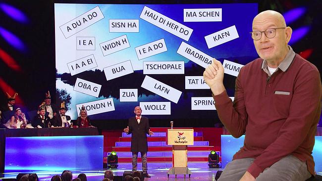 Auf einer Bühne steht Nachzipfer vor einem Rednerpult, während auf einer großen Leinwand viele Dialekt-Begriffe eingeblendet sind und links eine Jury sitzt. Vor der Szene sitzt der Nachzipfer in Alltagsbekleidung und kommentiert seinen Auftritt.