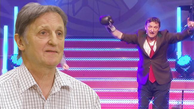 Noste im Anzug mit roter Krawatte jubelt auf einer beleuchteten Treppe und streckt einen Boxhandschuh in die Höhe. Links davon kommentiert Noste diesen Auftritt.