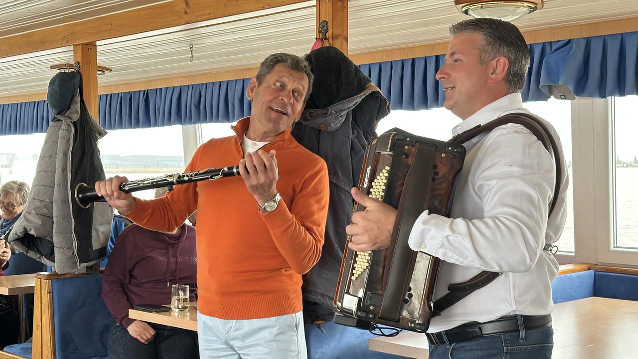 Franz Posch mit Klarinette spielt mit einem Mann mit einer Harmonika auf einem Ausflugsschiff bei der Mulatsag-Schiffahrt am Neusiedler See