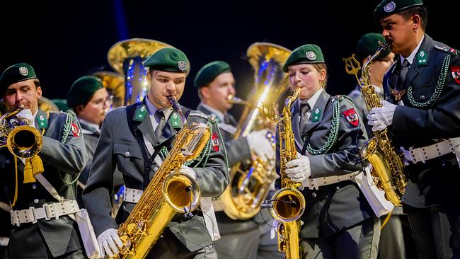 © ORF/Bundesheer/Carina Karlovits Musiker in Uniformen beim Militärmusikfestival 2026 in Graz, die auf der Bühne mit Saxofonen, Trompeten und Tuben musizieren.
