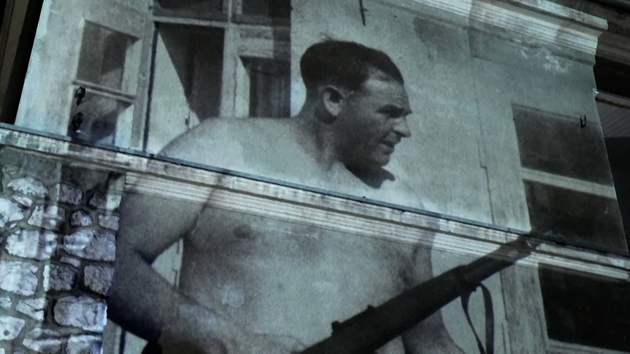 "Menschen & Mächte: Die drei Gerechten": Projektion eines Fotos von SS-Massenmörder Amon Göth auf einer Hauswand.