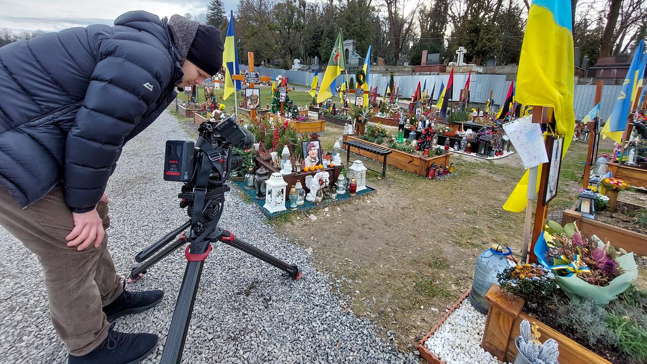 "Menschen & Mächte: Ukraine - der lange Kampf um Unabhängigkeit": Dreharbeiten auf einem Friedhof für Soldaten und Soldatinnen in Lviv mit Kameramann Wout Kichler.