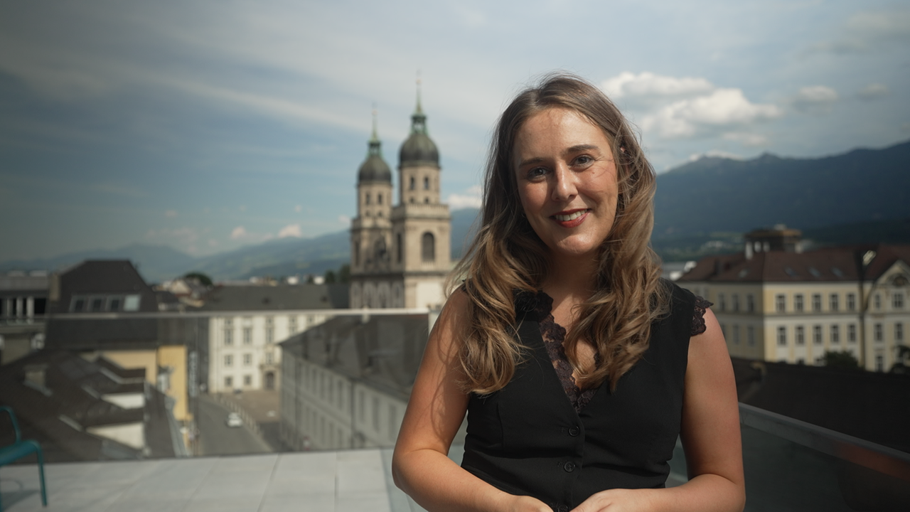 © ORF Tirol/Ferdinand Cibulka Frau auf einer Dachterrasse mit Blick auf die Innsbrucker Altstadt
