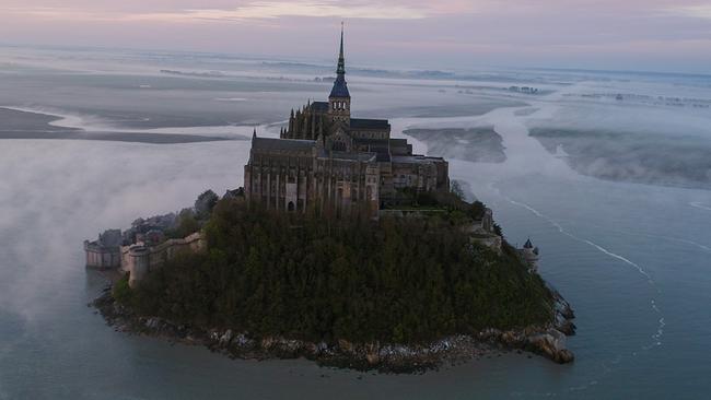 Mont-Saint-Michel ragt bei Nebel aus dem Wattenmeer der Normandie.