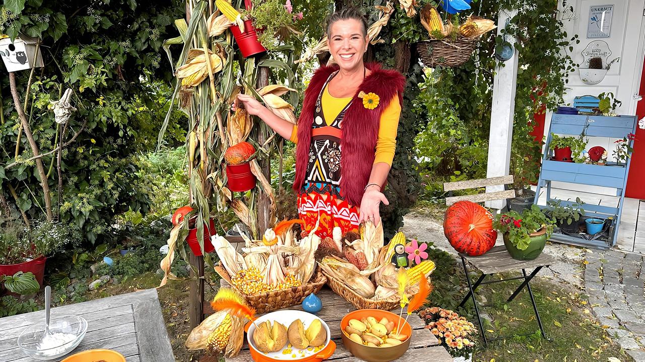 Kräuterhexe Uschi Zezelitsch vor einem herbstlich dekorierten Tisch mit Erdäpfeln und Mais