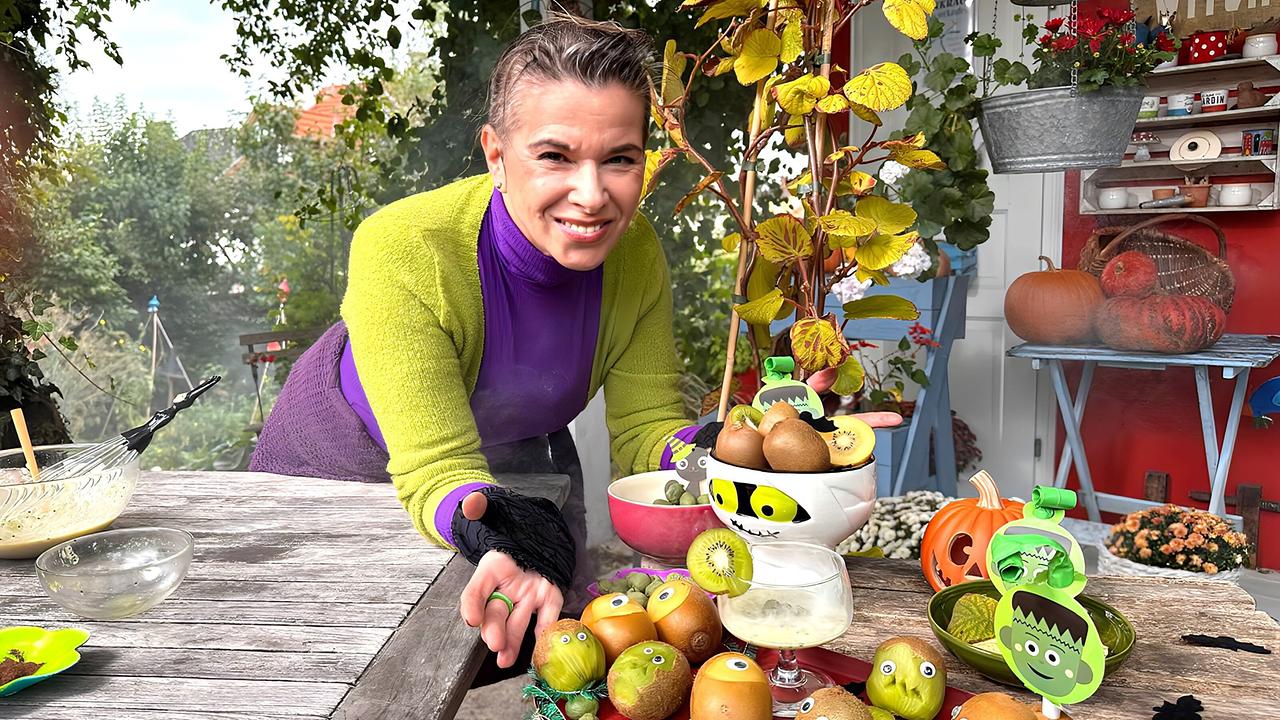 © ORF/Uschi Zezelitsch Kräuterhexe Uschi Zezelitsch vor für Halloween geschnitzten Kiwis auf einem Tisch