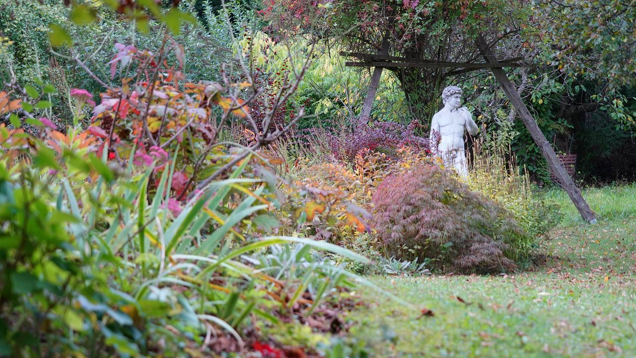 © Leopold Mayrhofer/Natur im Garten Grüne Wiese mit bunten Sträuchern, Obstbaum und Marmorstatue