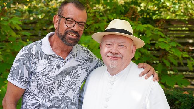 © Leopold Mayrhofer/Natur im Garten Karl Ploberger und Kräuterpfarrer Benedikt stehen Arm in Arm vor grünem Laubhintergrund im Garten.