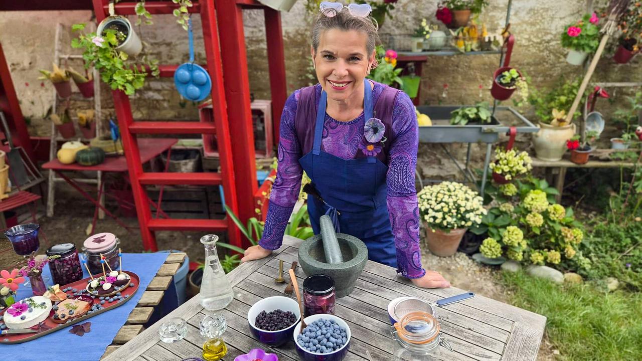 Uschi Zezelitsch mit Mörser und Heidelbeeren am Gartentisch: Zutaten für Fermentation und Saucen-Herstellung.