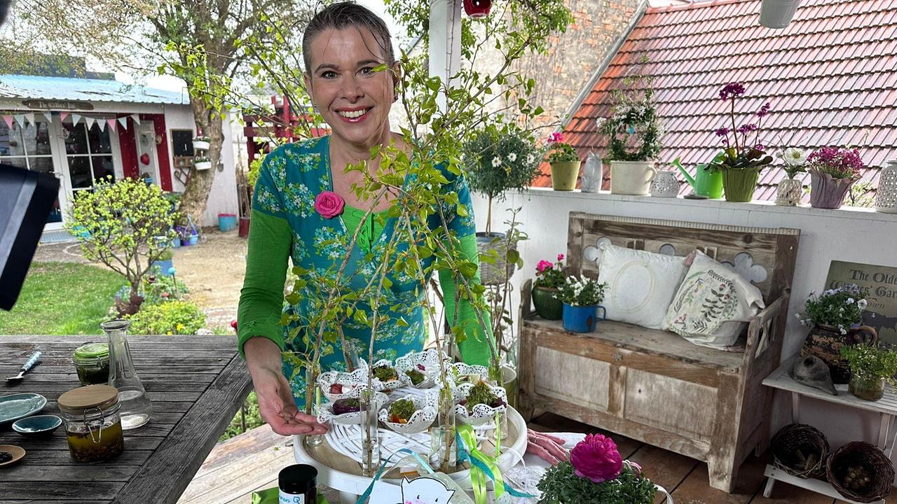Uschi Zezelitsch an einem Holztisch mit kleinen Portionen ihrer fermentierten Espenblättern.