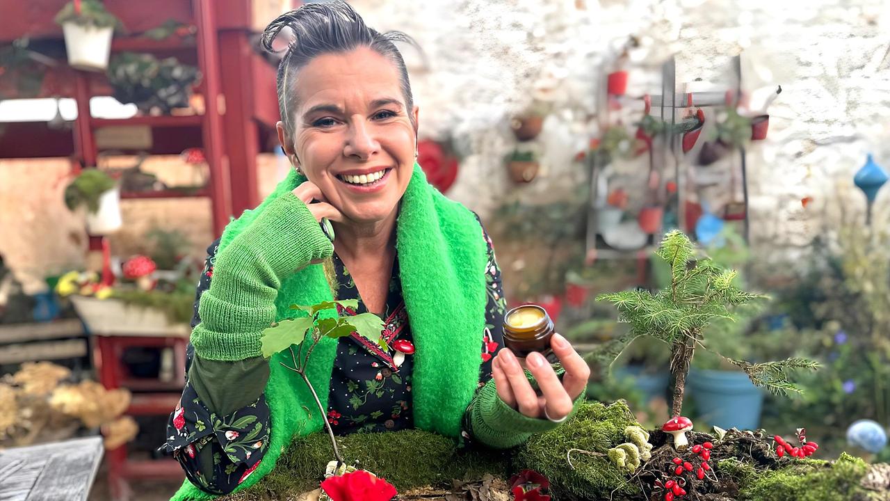 Uschi Zezelitsch hält ein kleines Glas ihrer Hautsalbe in der Hand 