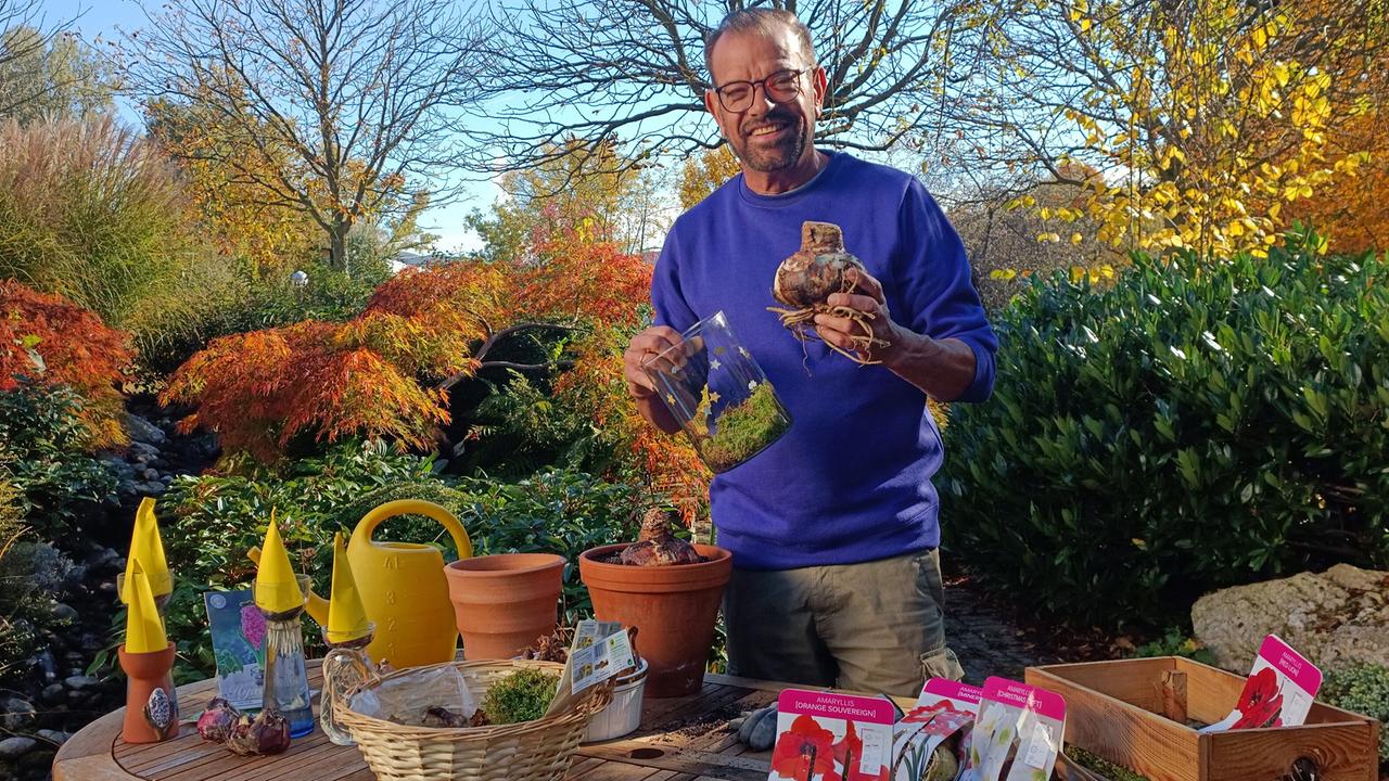 Karl Ploberger hinter einem Garten-Tisch mit Pflanztöpfen und Blumenzwiebeln