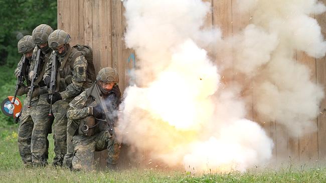 4 Personen in Bundesheer-Kleidung neben Rauchwolke