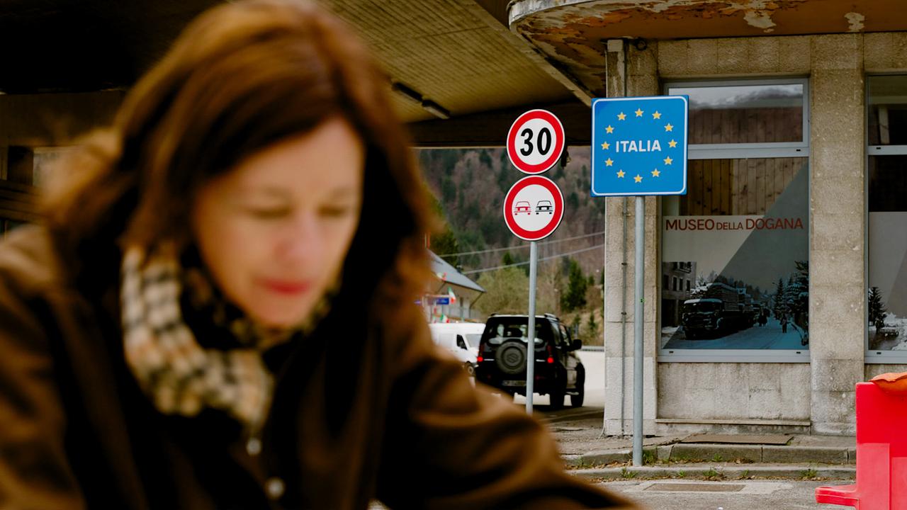 Julia Cencig beim alten Grenzübergang nach Italien  vor einem „ITALIA“-Schild.