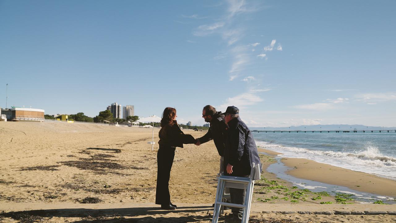 Julia Cencig am Strand im Gespräch mit Marosa und Marco, Rettungsschwimmer und Strandaufsicht in Lignano.